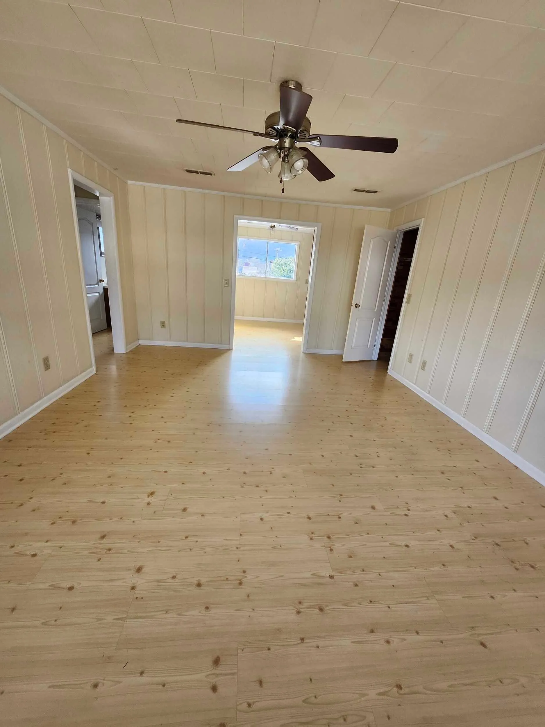 Brickstone Square room with wood floors and a ceiling fan viewed from the doorway