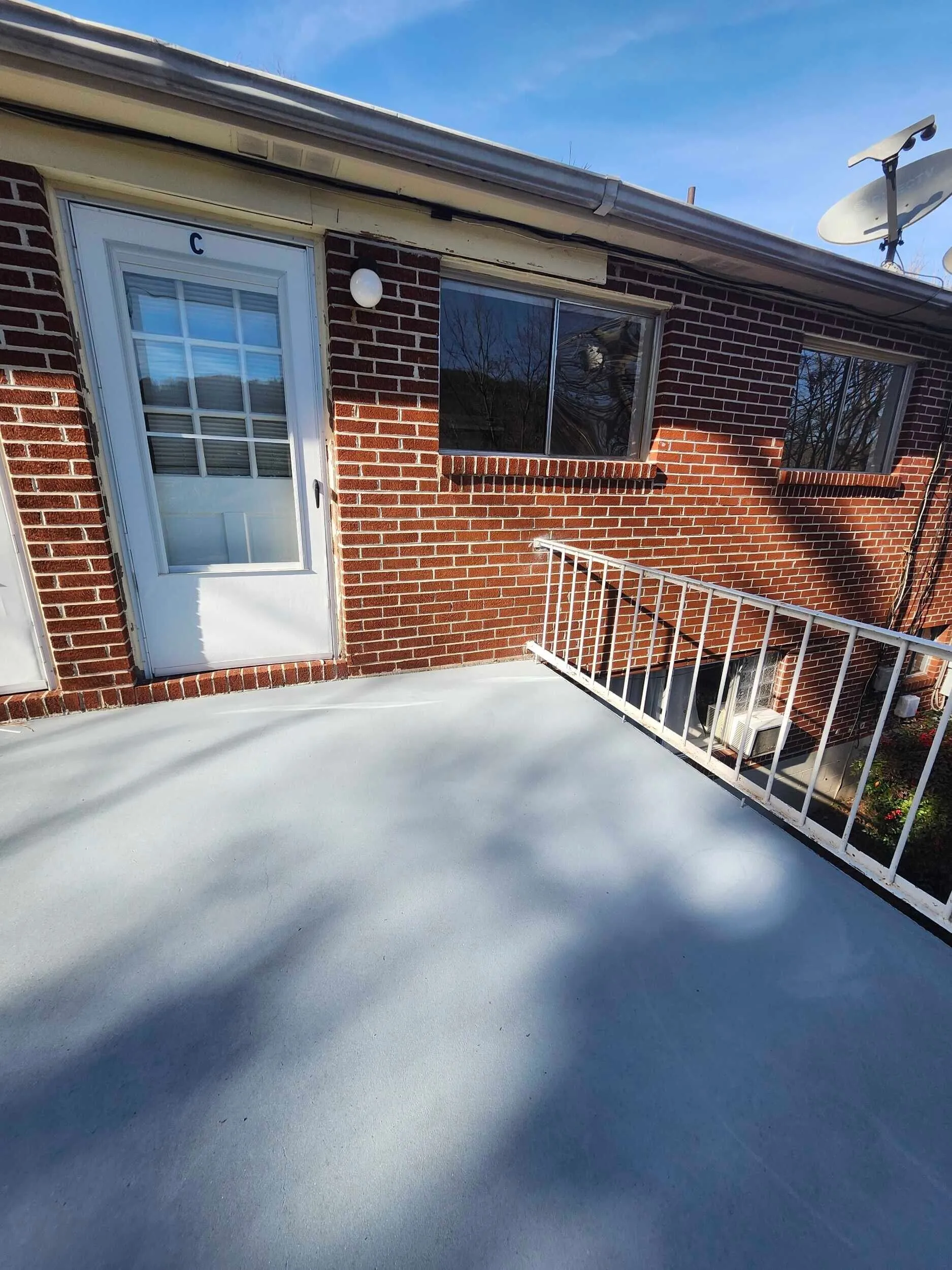 Brickstone Square brick exterior with a white entry door and front landing