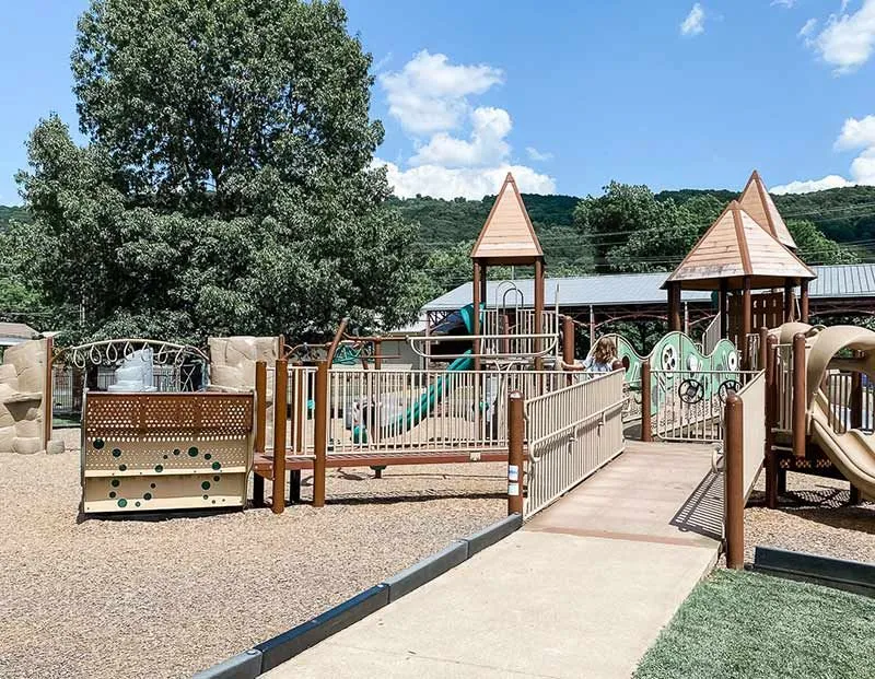 Outdoor playground with climbing structures and an accessible ramp